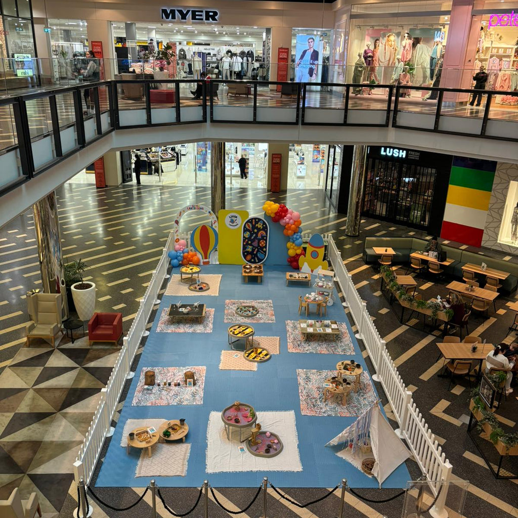 Mall interior with a large indoor play area featuring colorful toys and games.